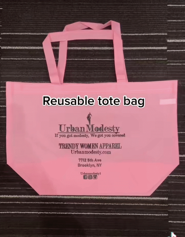 a pink reusable tote bag with the words urban modesty on it