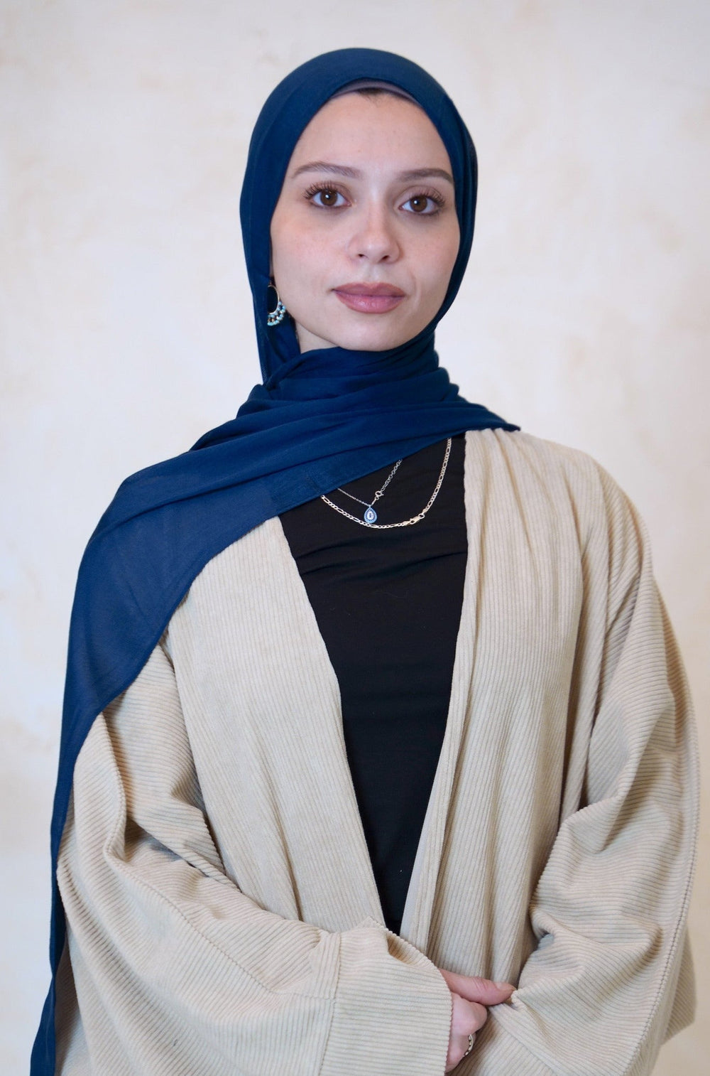 a woman in a black top and a blue shawl