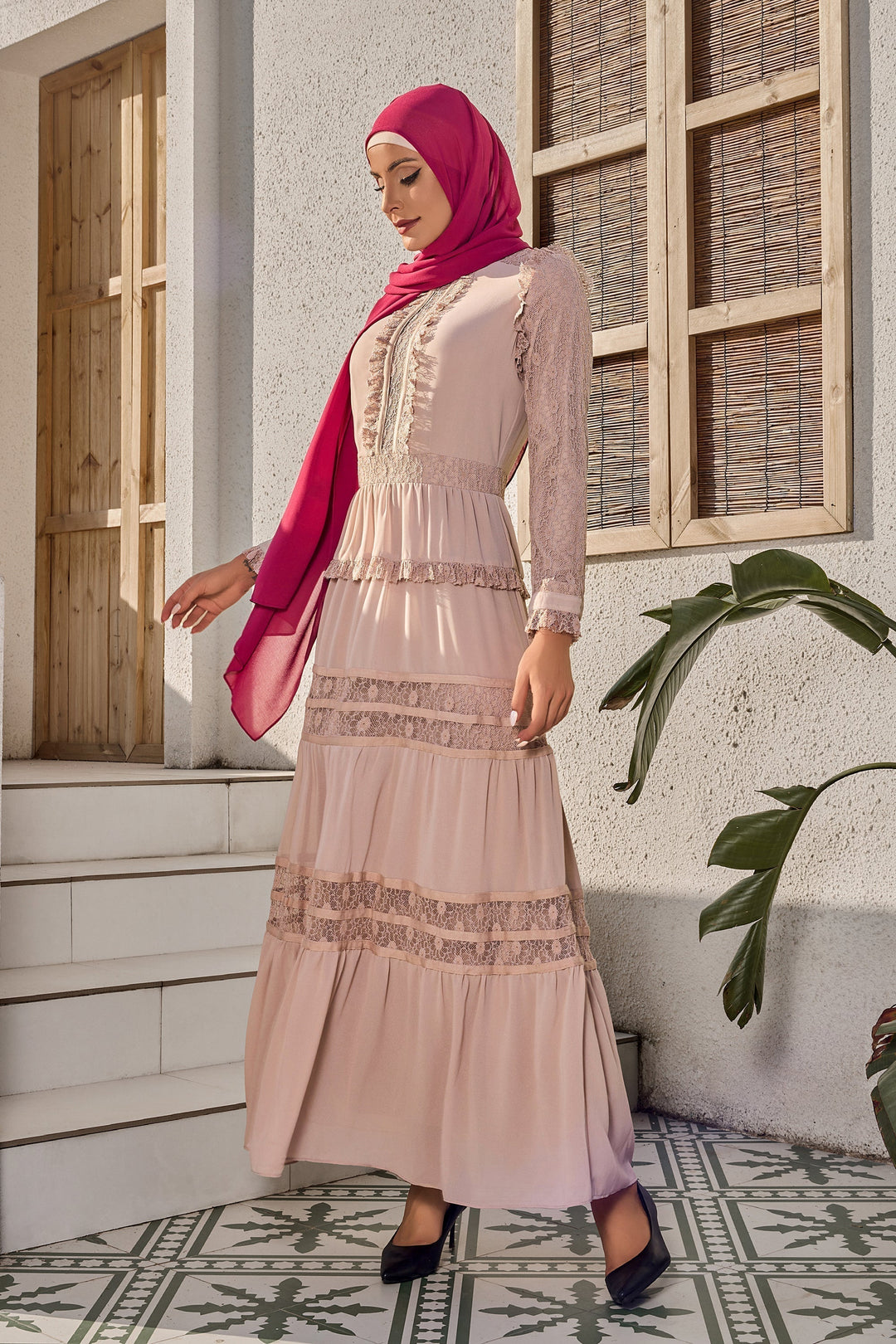 a woman wearing a pink dress and a hijab