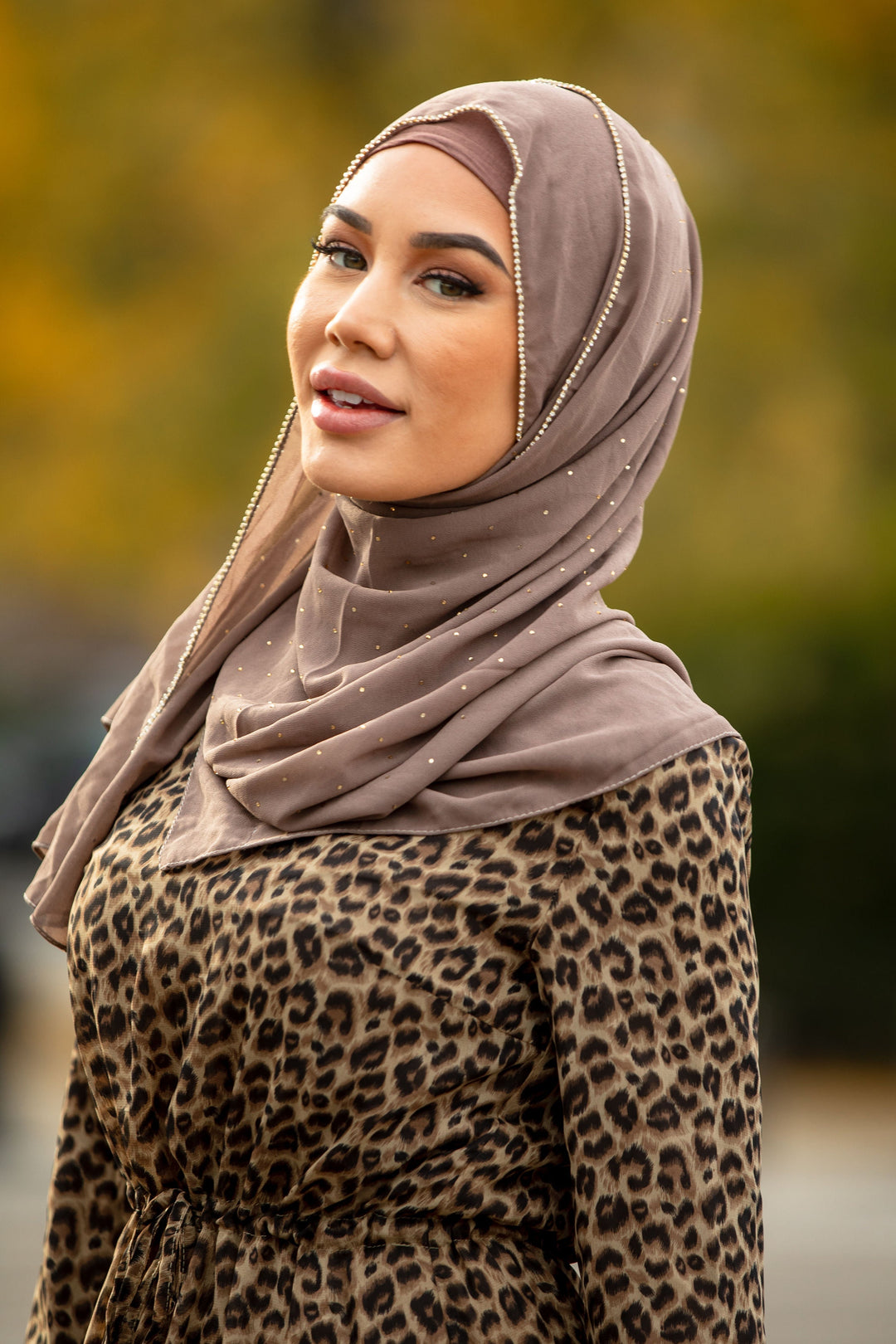 a woman in a leopard print dress and a headscarf