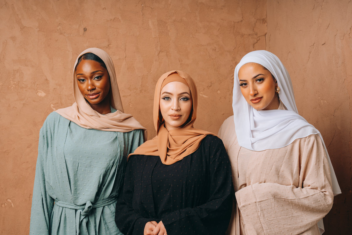 Three women in elegant flowing dresses, representing timeless fashion from the New Year’s Best for 2026 collection.