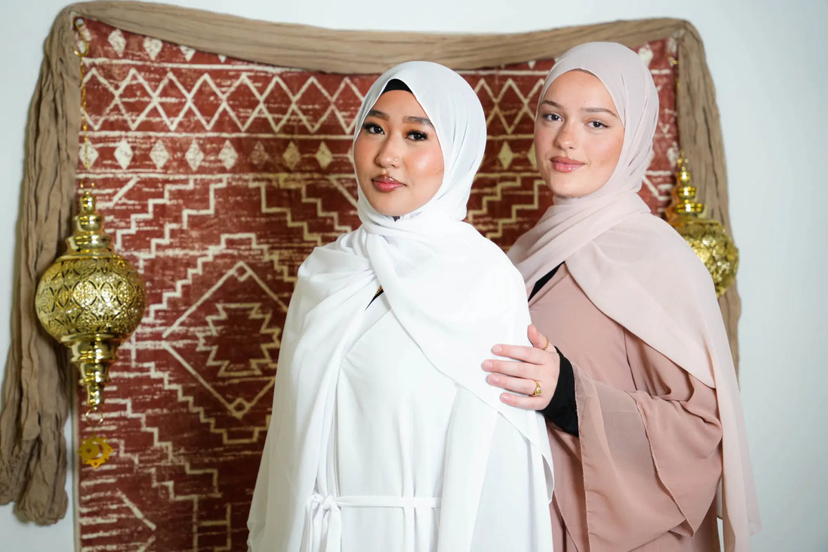 Women wearing elegant Chiffon Hijabs with traditional decor in the background, highlighting lightweight and versatile style.