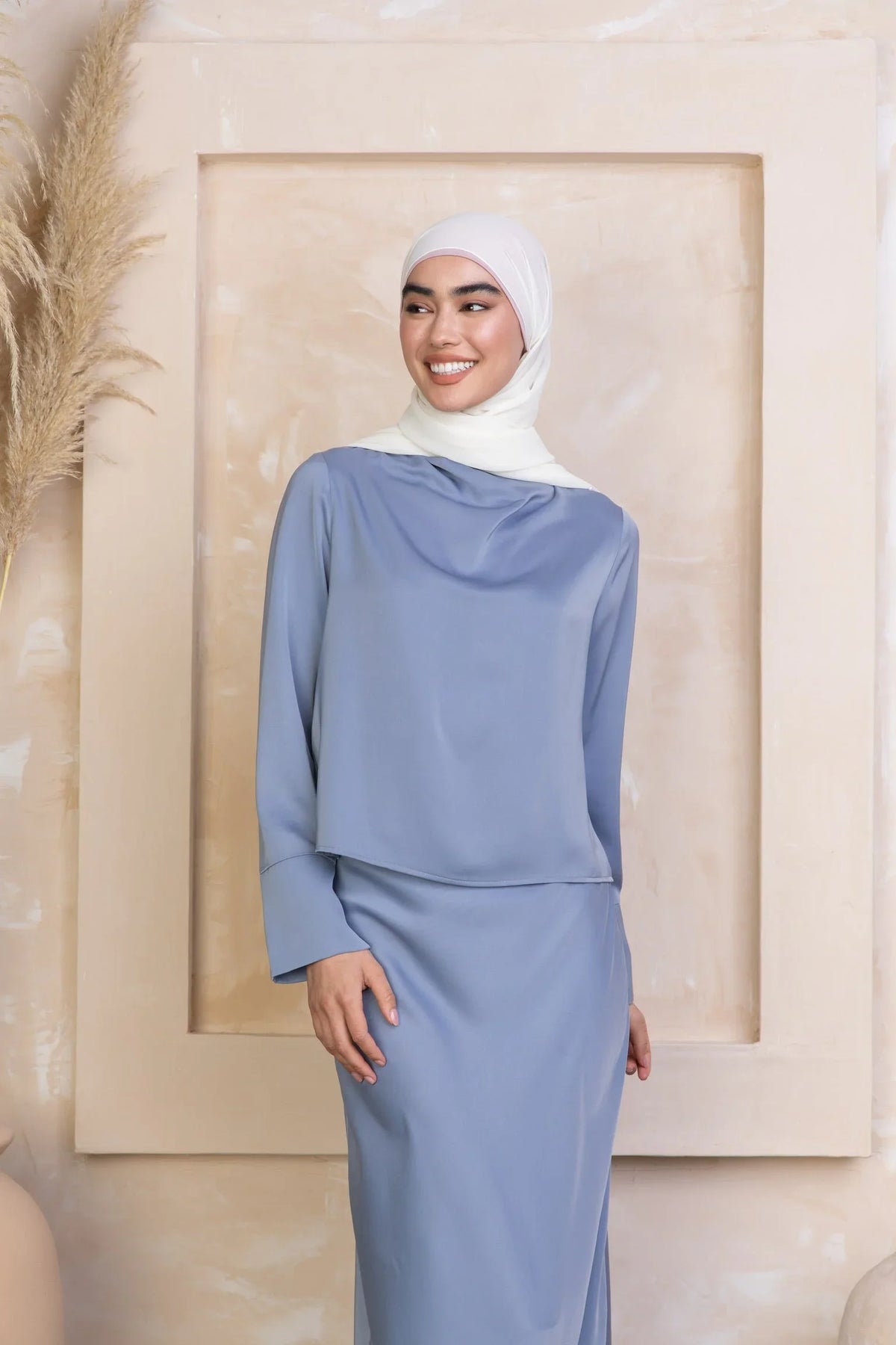 Woman wearing modest pink dress and black hijab outside near brick building, available in Clearance Sale at Urban Modesty.