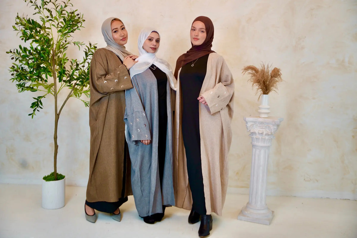 Women modeling stylish Open Front Abayas with flowy silhouettes and tie belts, showcasing modest yet modern fashion.