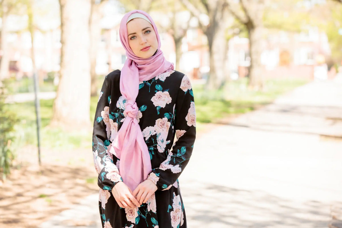 Woman wearing pink shimmer hijab with floral dress outdoors, perfect for Eid, parties, or special occasions, adding sparkle and elegance.