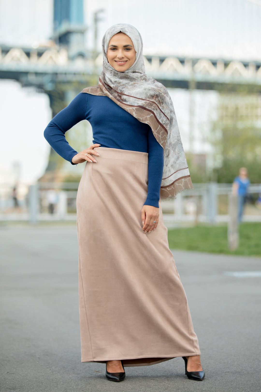 Woman wearing Sand Suede Pencil Maxi Skirt with blue top and headscarf standing outdoors.