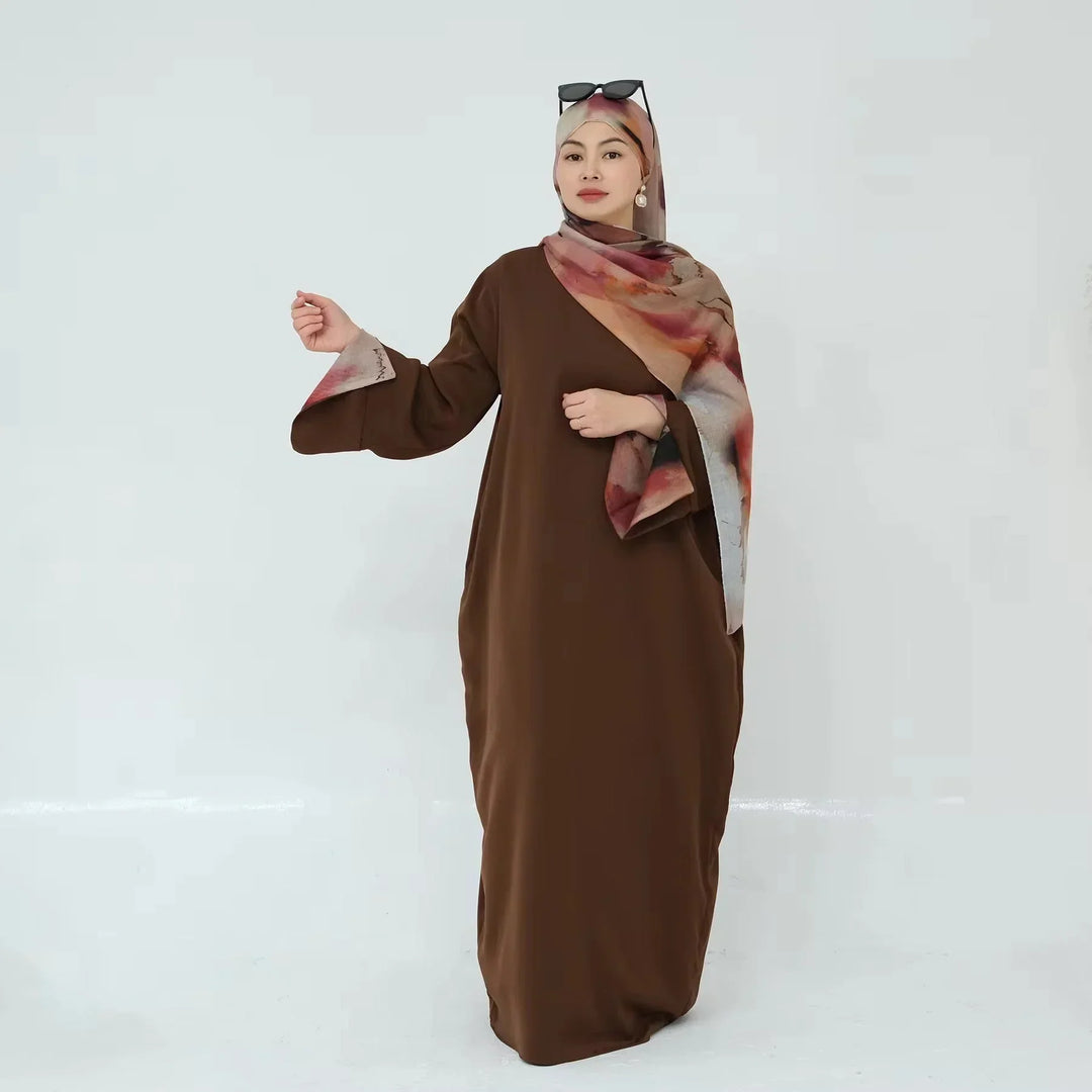 Woman wearing Brown Marbled Abaya with flowy kimono sleeves and matching hijab, showcasing elegant design and premium fabric.