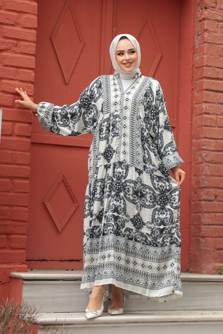 Woman in a patterned long-sleeve maxi dress standing in front of a red door.