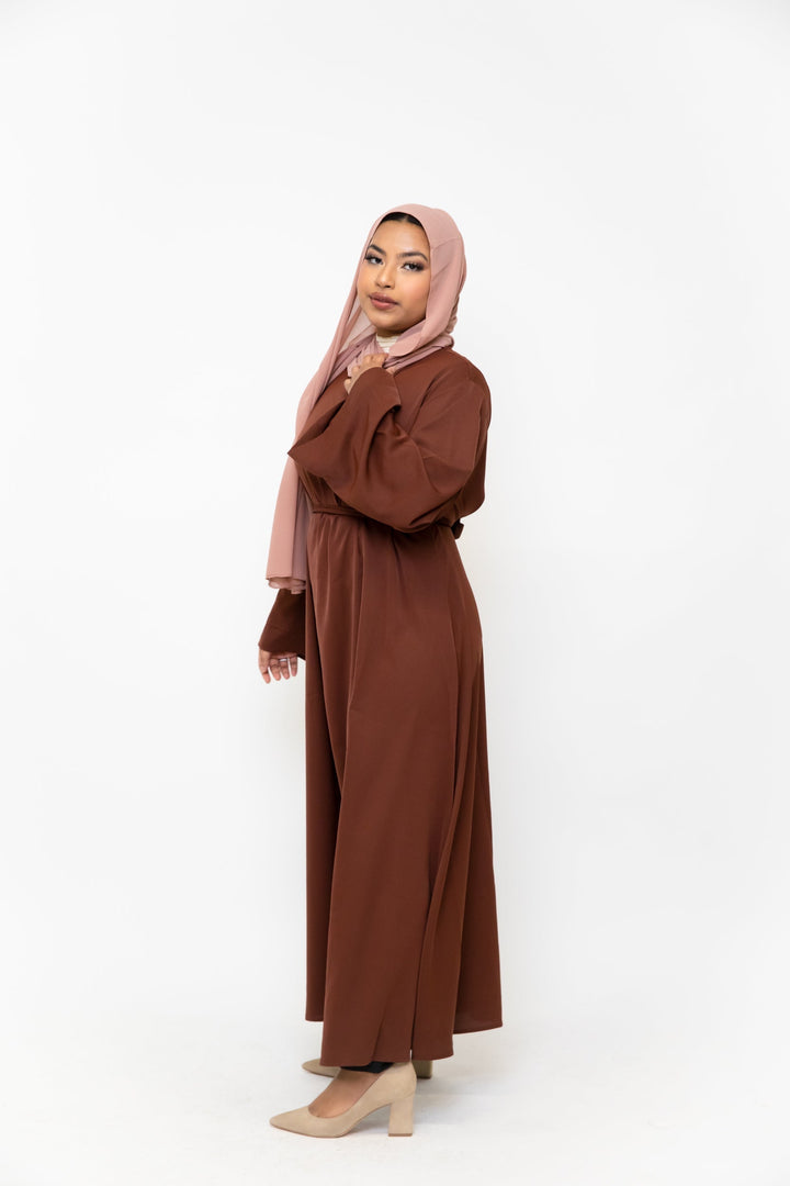 Woman in brown kimono sleeve abaya maxi dress and pink hijab