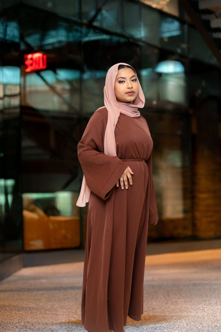 Woman in brown kimono sleeve abaya maxi dress with pink hijab