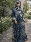 Woman wearing Blue Abstract One Piece Salah Prayer Outfit in garden setting, breathable and comfortable attire for Hajj and Umrah.