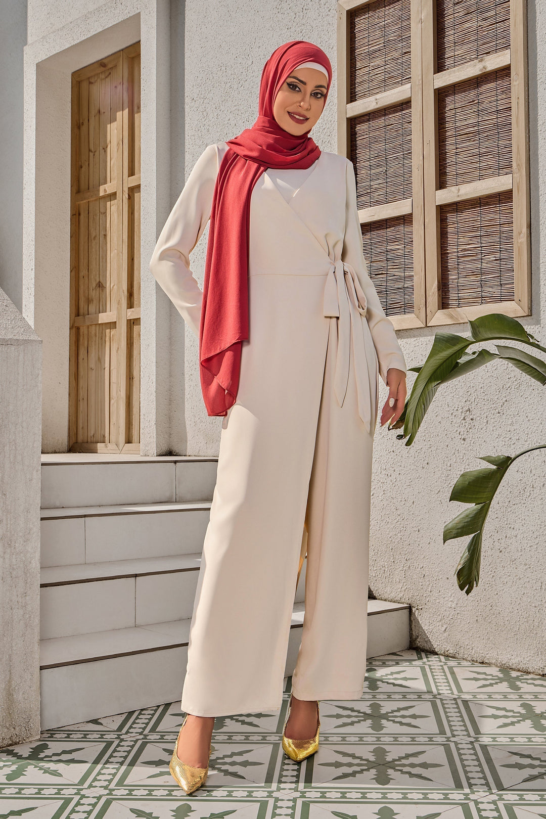 Woman in cream side knot jumpsuit and hijab