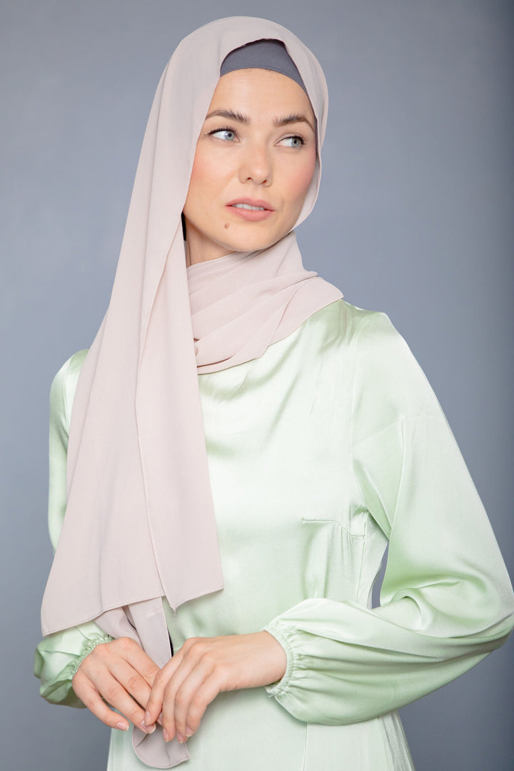 Woman in latte chiffon hijab and light green satin dress