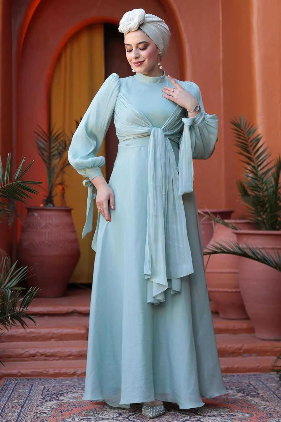 Mint Blue Organza Criss Cross Gown with elegant fit and flare silhouette, crew neckline, and back zipper displayed outdoors.