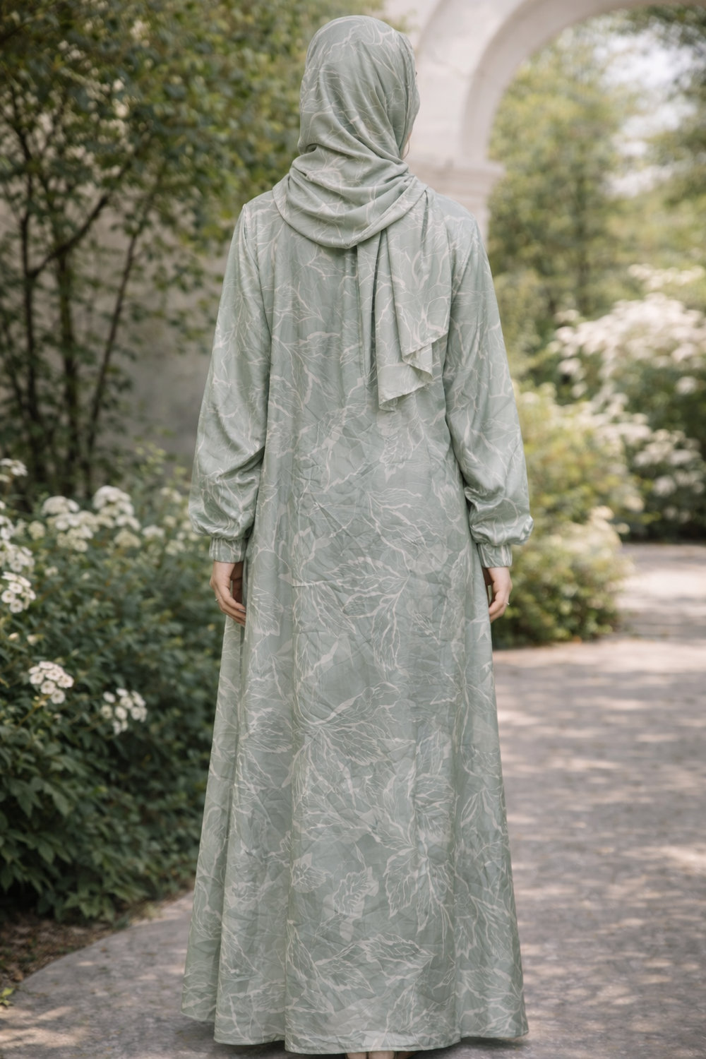 Back view of Mint Vines One Piece Salah Prayer Outfit in a garden setting, showcasing breathable fabric and elegant design for Hajj or Umrah.