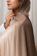 Woman wearing light brown Ombré Jersey Hijab, showcases lightweight, drapable fabric. Perfect for effortless style in staple colors.