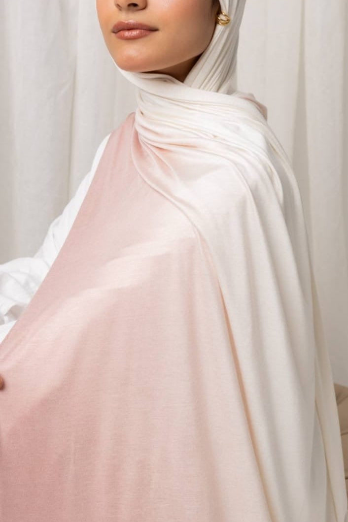 Ombré Jersey Hijab in soft pink and white, lightweight and easy to drape, shown on a person in a stylish setting.