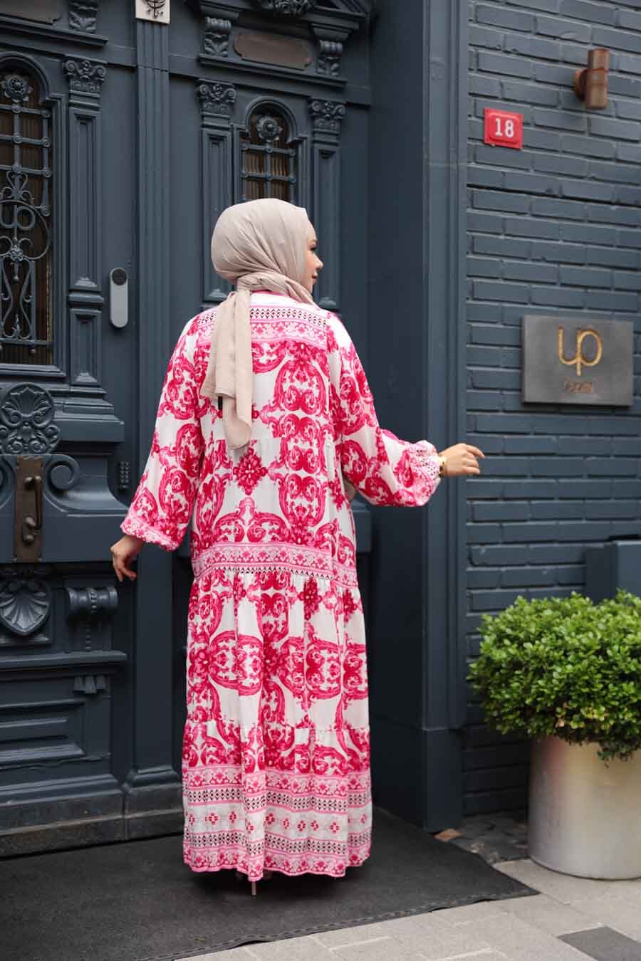 Woman wearing Pink Tropical Smocked Maxi Dress-CLEARANCE standing by blue door on city street.