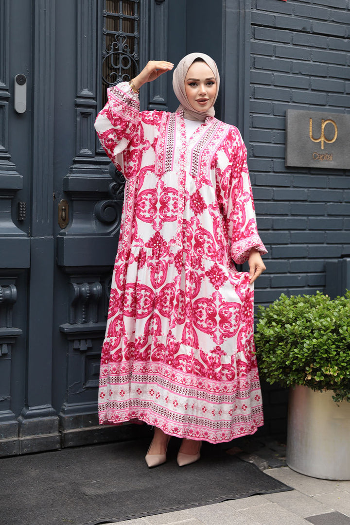 Model wearing Pink Tropical Smocked Maxi Dress-CLEARANCE with elastic cuffs and ruffle hem, outdoor urban background.
