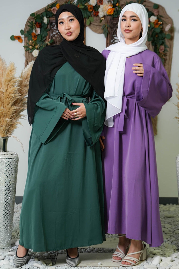 Two women in modest purple kimono sleeve abaya maxi dresses and hijabs