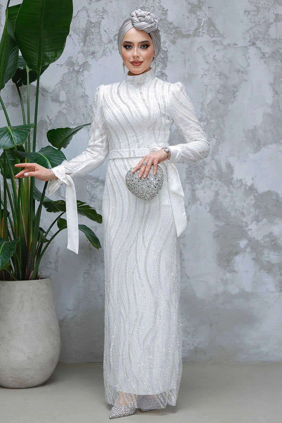 White Beaded Gown from Urban Modesty with elegant detailing, crew neckline, long sleeves, and a stylish slim fit, perfect for events.