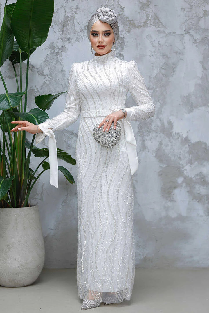 White Beaded Gown from Urban Modesty with elegant detailing, crew neckline, long sleeves, and a stylish slim fit, perfect for events.