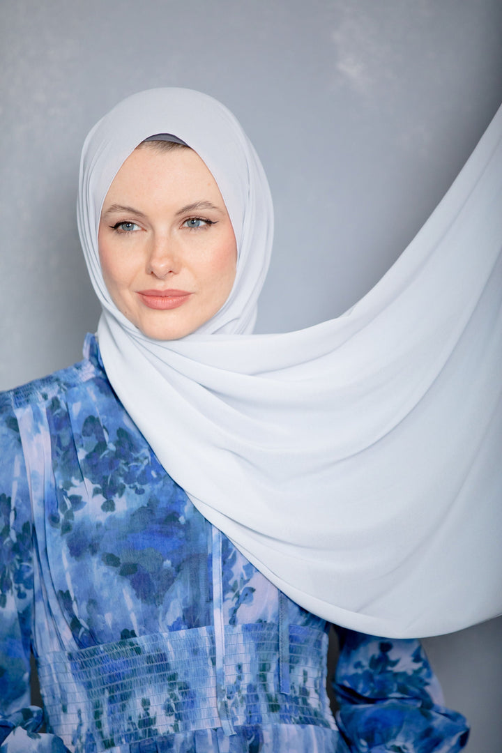 Woman in blue dress and white chiffon hijab
