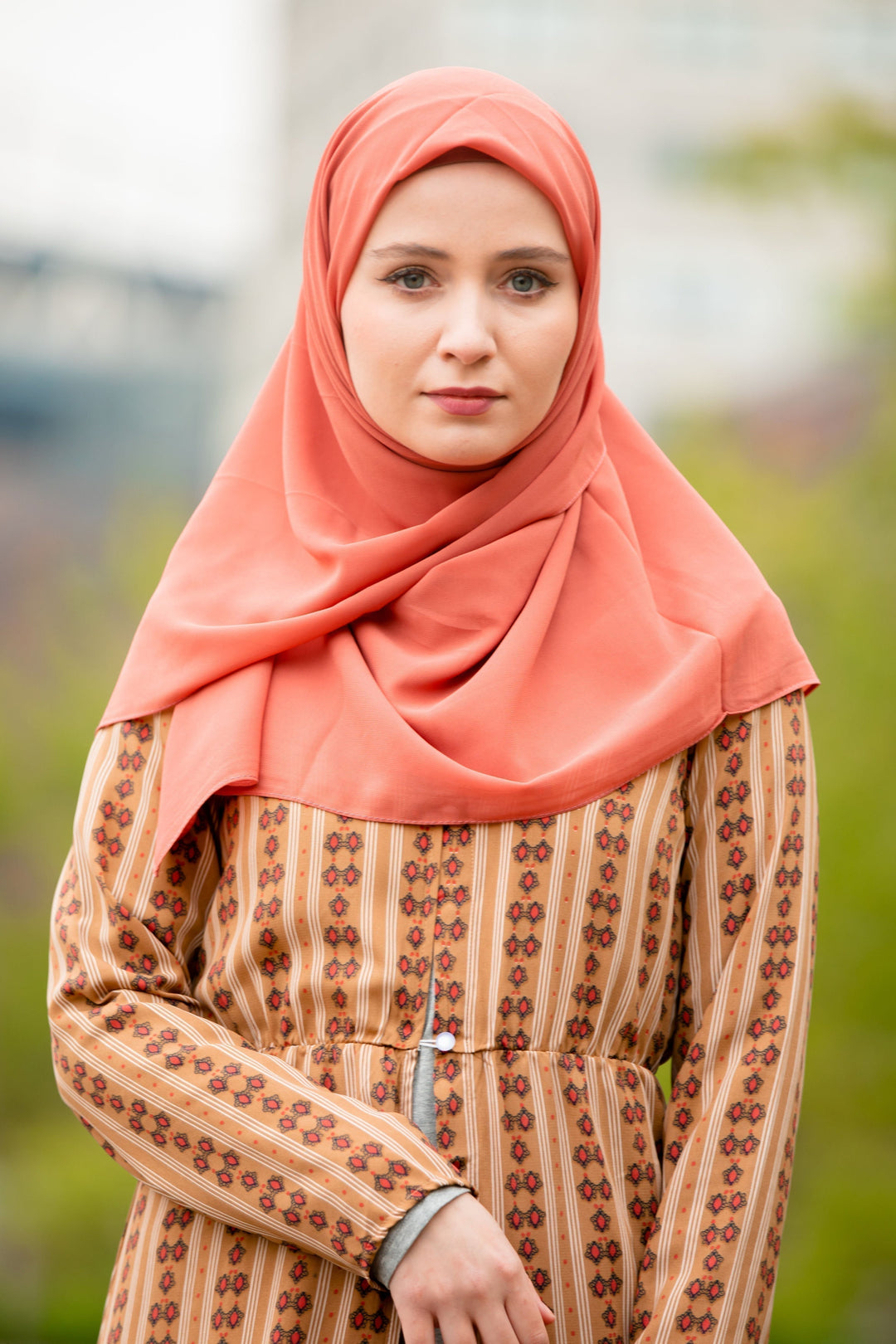 Woman in a hijab with an Apricot Chiffon Scarf and a patterned dress