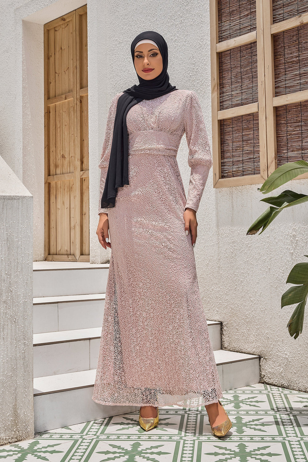 Woman in beige lace ruched waist long sleeve gown with sequins and hijab