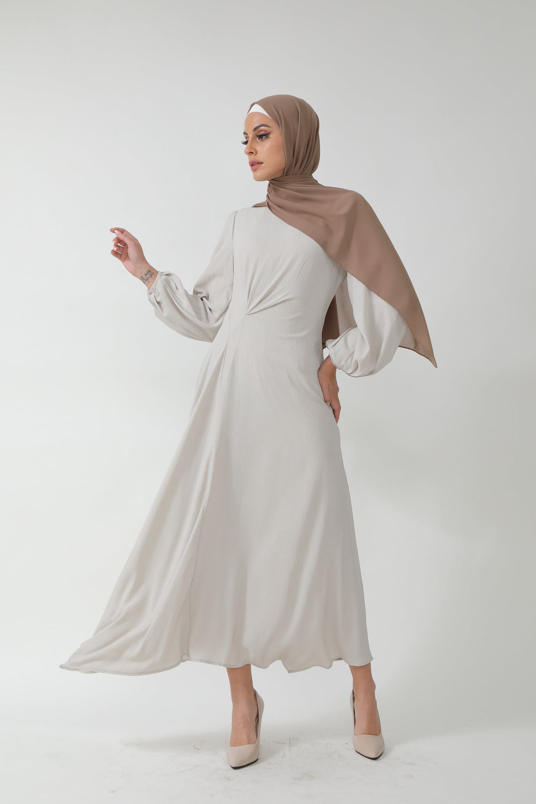 Woman in a beige metallic pinstripe long sleeve maxi dress with hijab on clearance