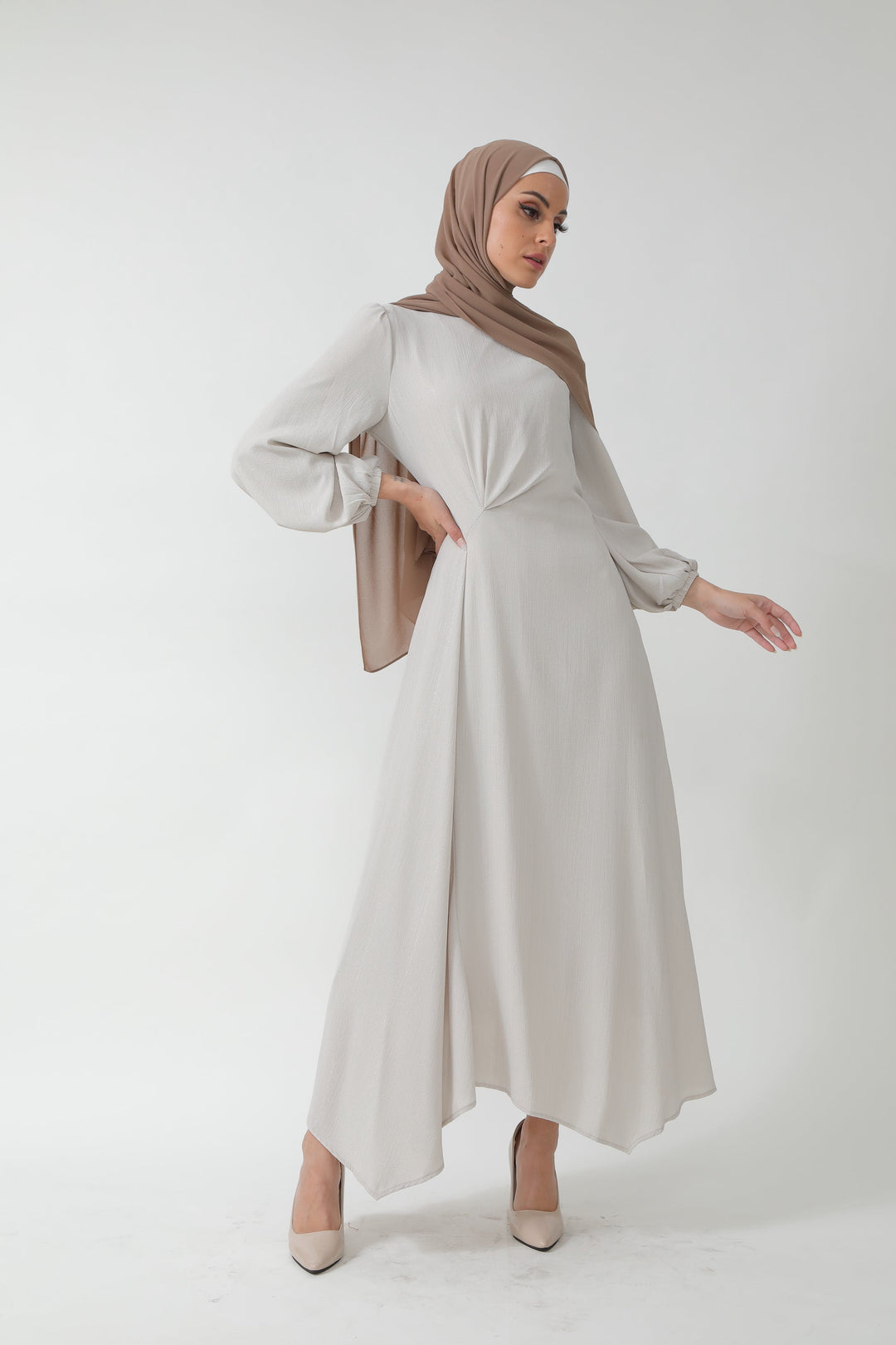 Woman in a modest, light-colored metallic pinstripe long sleeve maxi dress