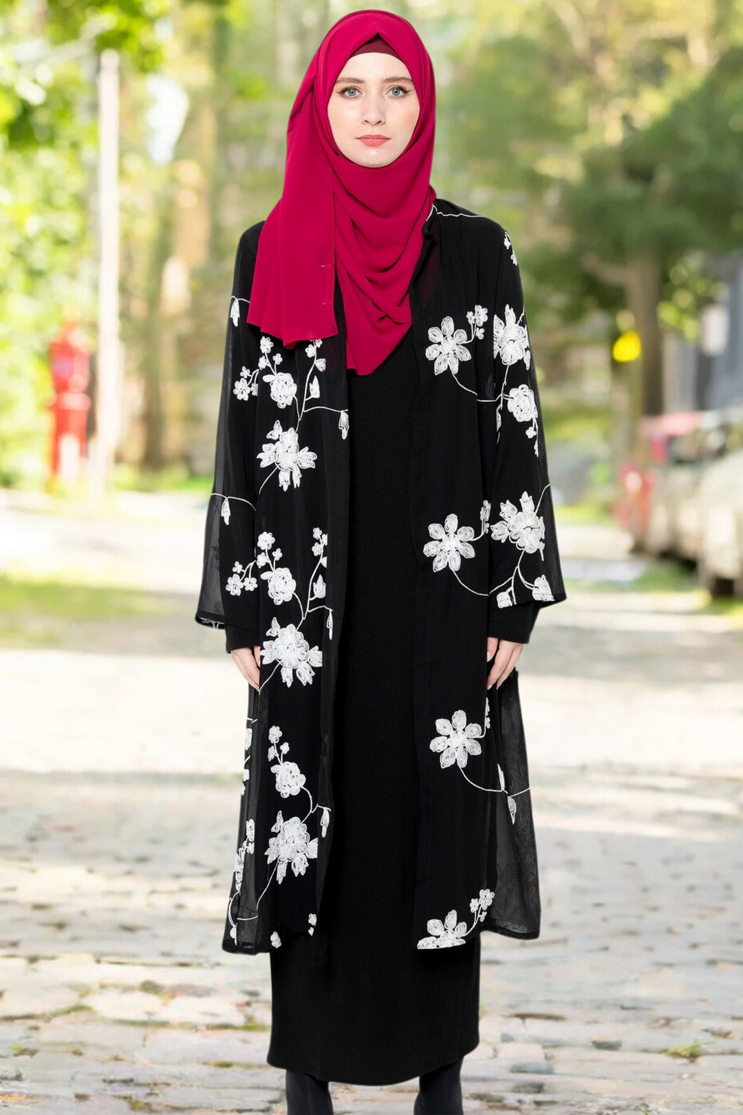 Woman in black dress and floral cardigan featuring white embroidered sheer design