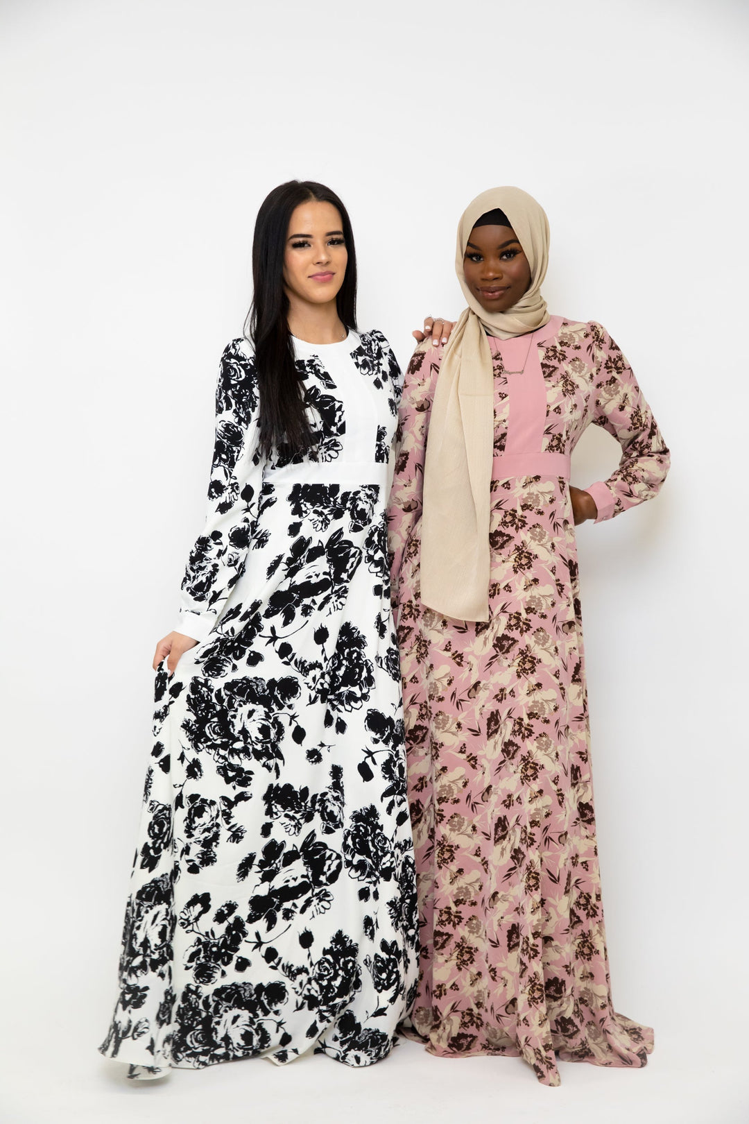 Two women in long, floral dresses showcasing the Black and White Floral Maxi Dress