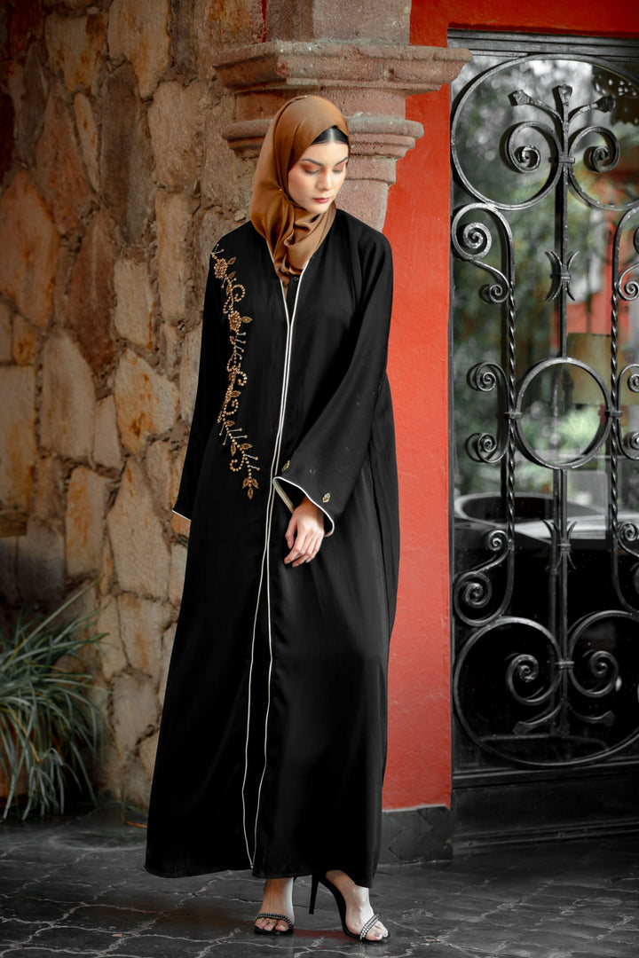 Elegant black abaya with gold embroidery, featuring a black beaded button design