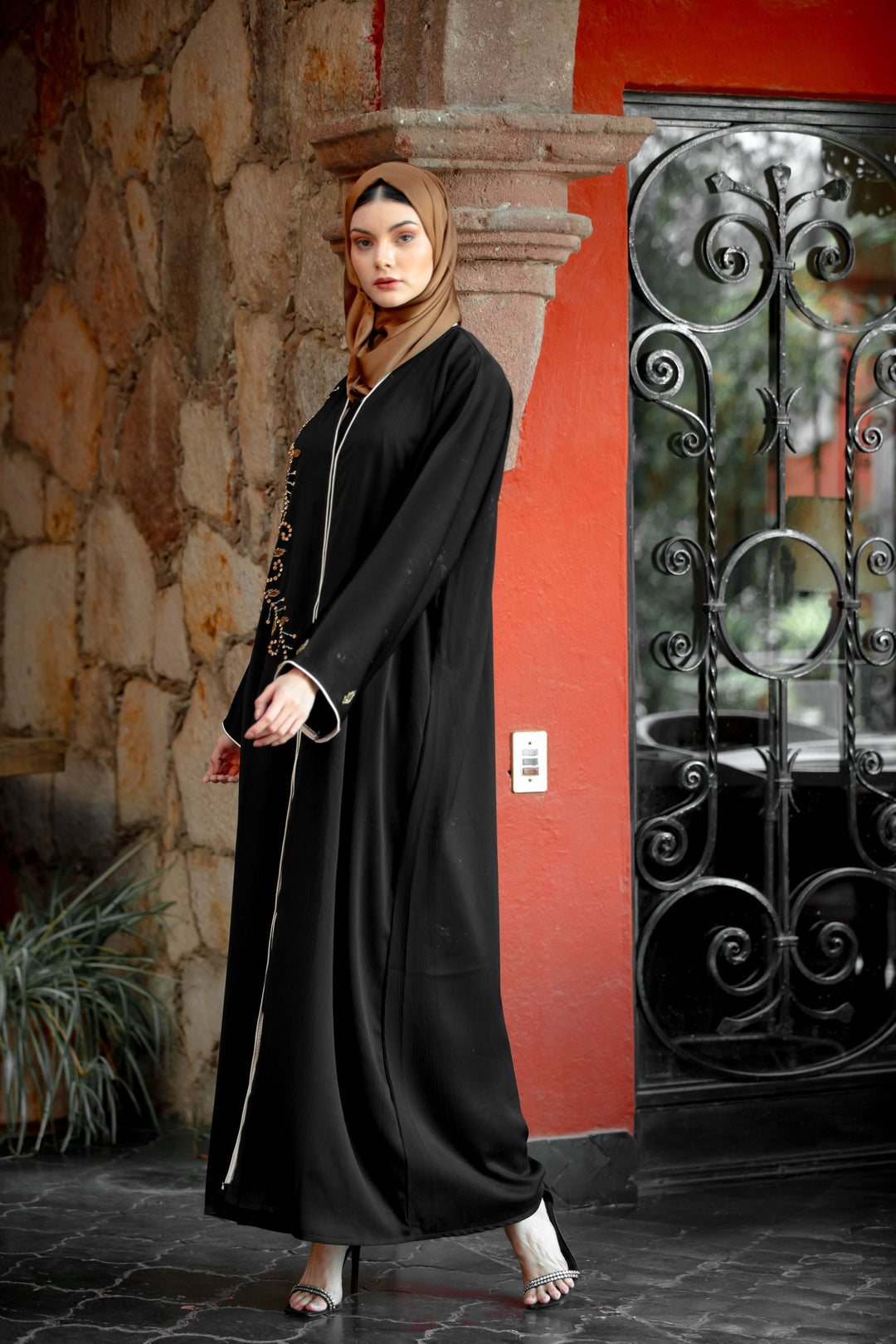 Elegant black abaya with white trim featuring black beaded button design