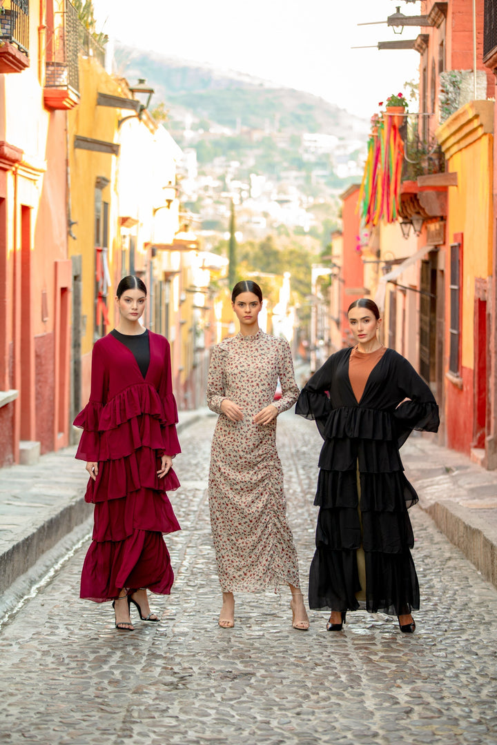 Three women modeling the Black Cascading Ruffles Open Front Abaya with tiered ruffles