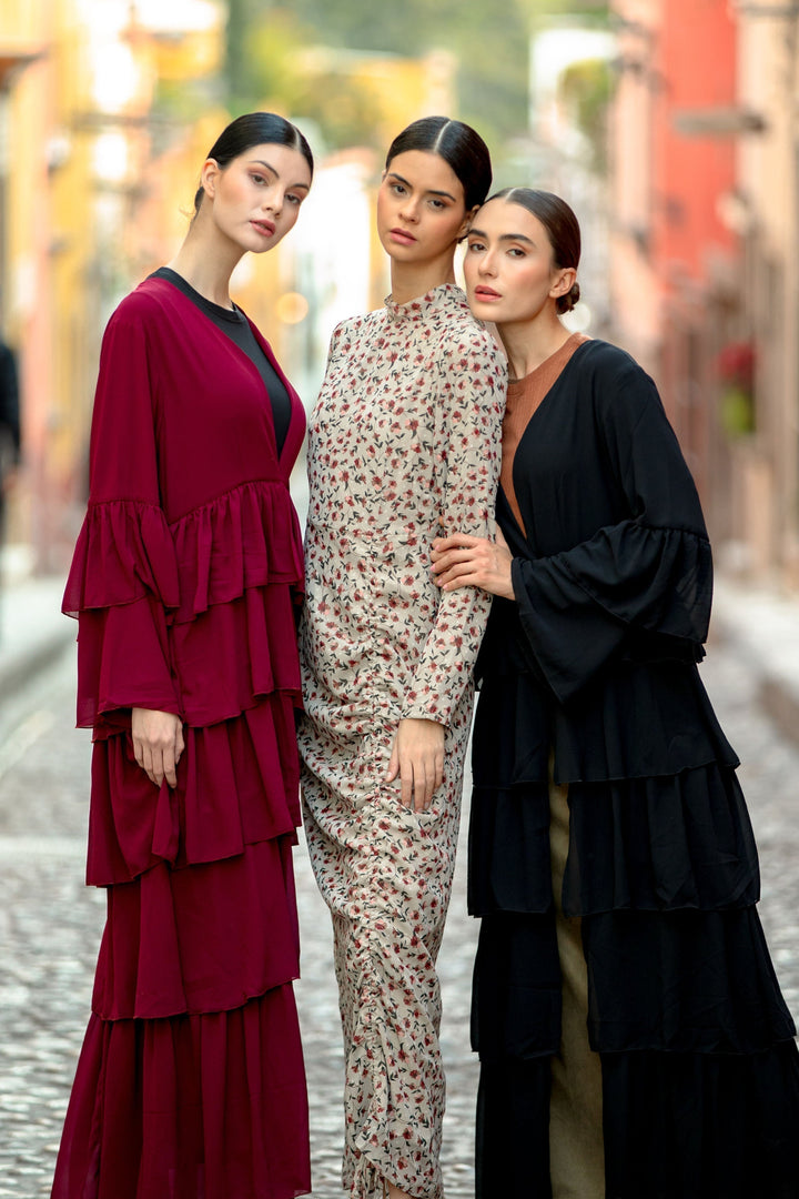 Three women modeling Black Cascading Ruffles Open Front Abaya with tiered ruffles