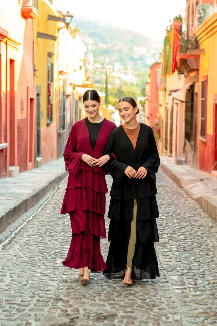 Two women in elegant Black Cascading Ruffles Open Front Abaya with tiered ruffles