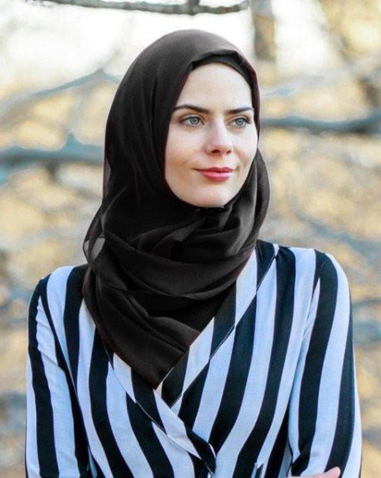 Woman in a black hijab and striped shirt showcasing a Black Chiffon Hijab scarf