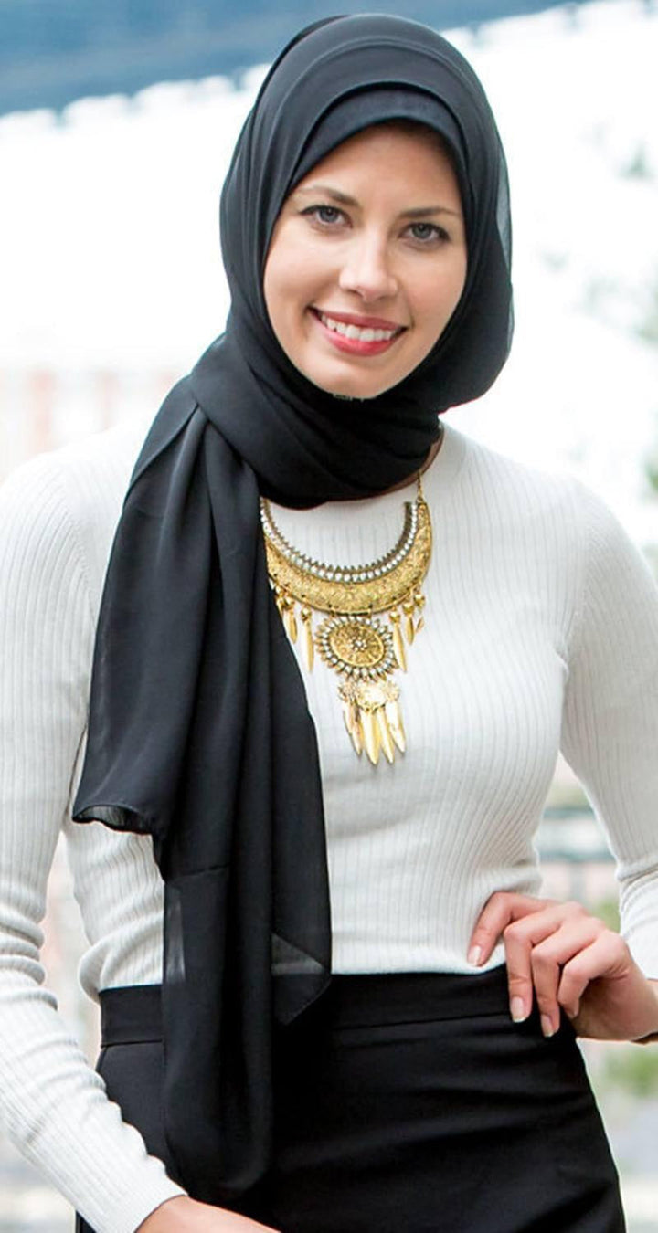 Smiling woman in hijab showcasing a Black Chiffon Hijab and statement necklace