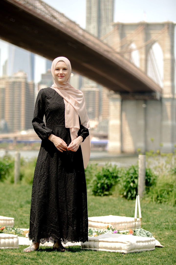 Woman wearing a black eyelet long sleeve maxi dress with a hijab