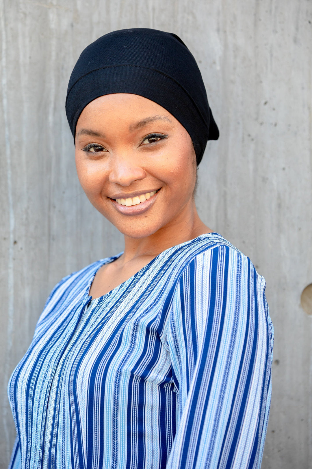 Smiling woman wearing a striped shirt and Black Hijab Tube Underscarf undercap