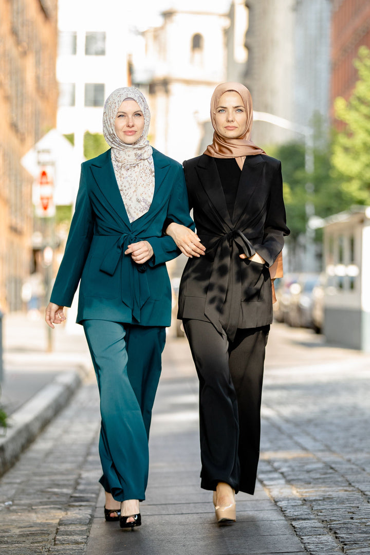 Two women in stylish modest suits featuring a black jacket and tailored pants set