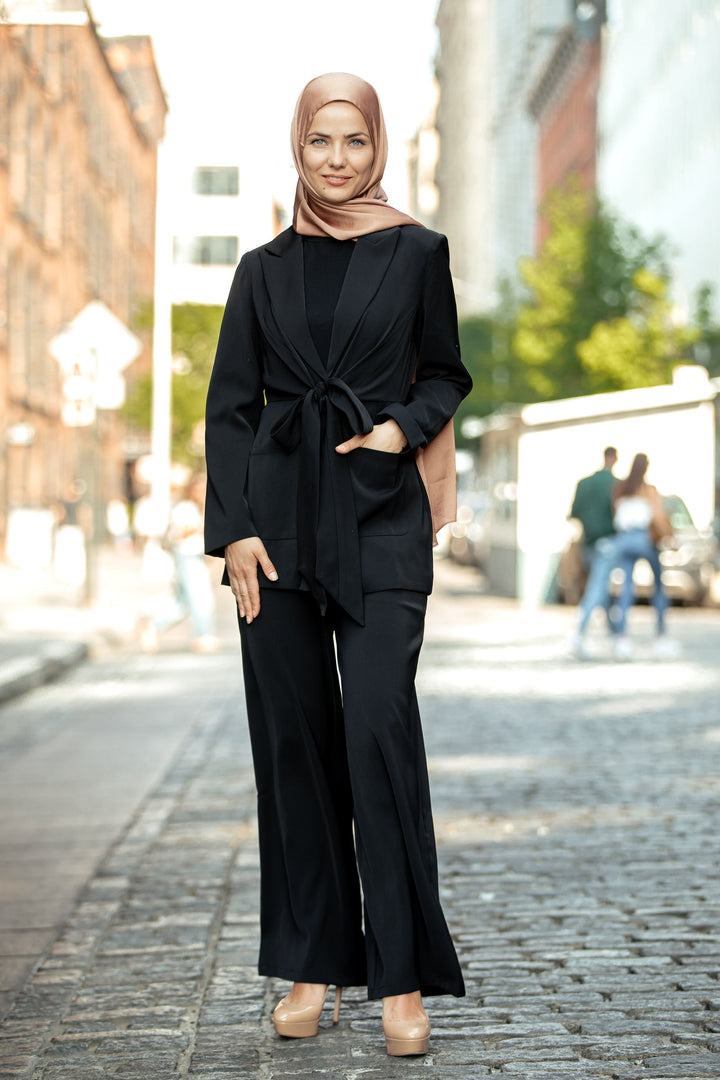 Woman wearing a black jacket and pantsuit set with hijab for stylish occasions