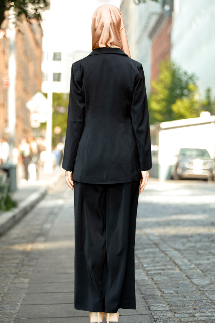 Woman in black suit with hijab featuring a stylish black jacket and pants set