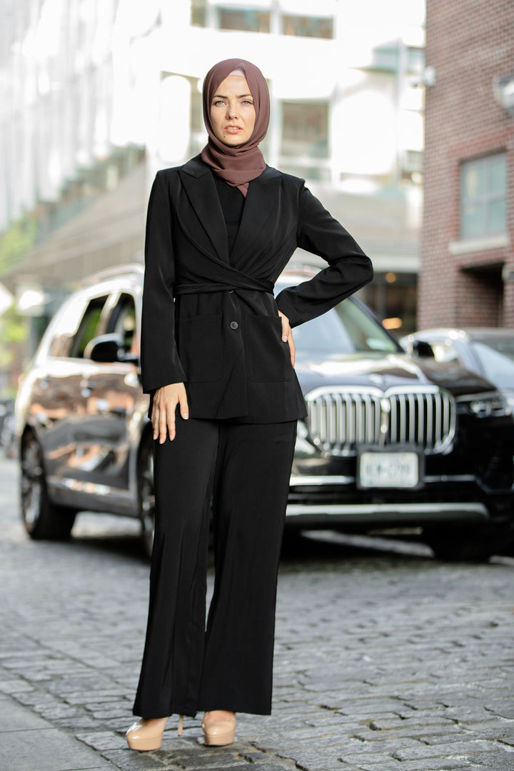 Woman in black pantsuit and hijab modeling a stylish black jacket and pants suit set