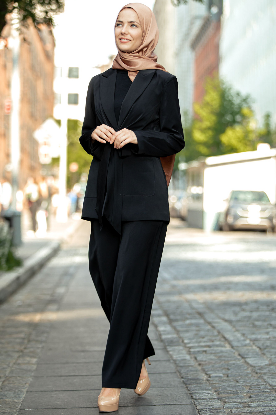 Woman in black pantsuit and hijab showcasing a stylish black jacket and pants suit set