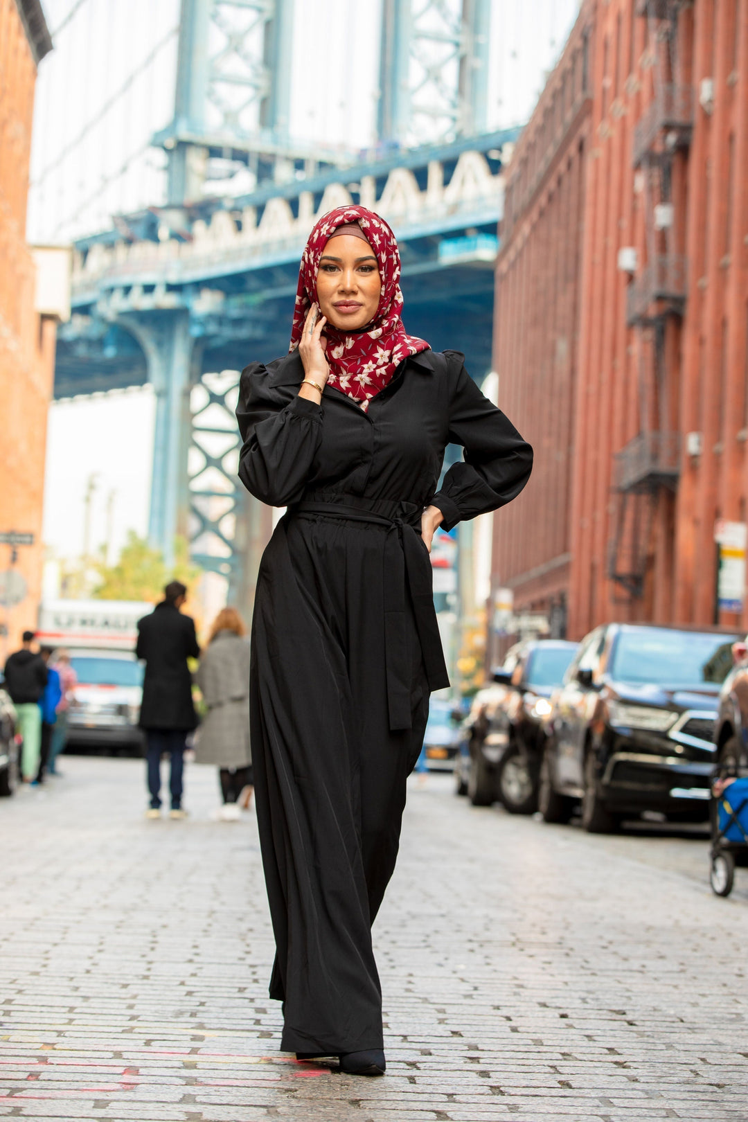 Woman in black jumpsuit and floral hijab modeling Black Lattice Jumpsuit on clearance