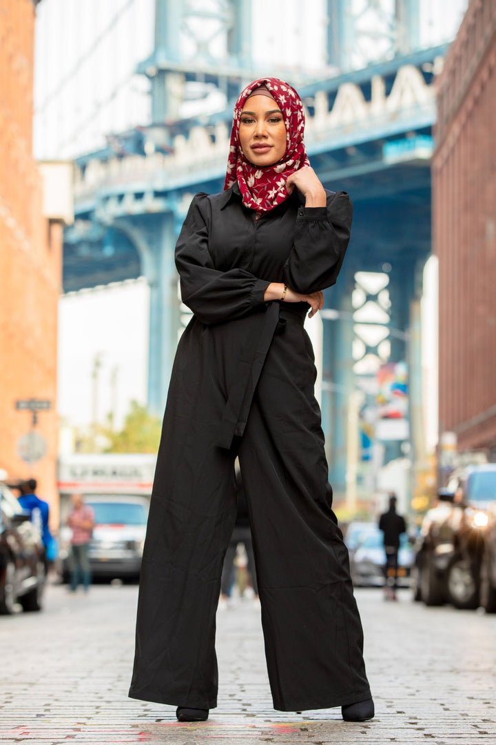 Woman in black jumpsuit and floral hijab showcasing Black Lattice Jumpsuit on CLEARANCE