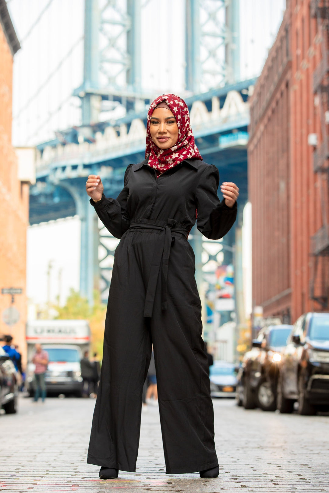 Woman in black jumpsuit with floral hijab showcasing Black Lattice Jumpsuit on clearance